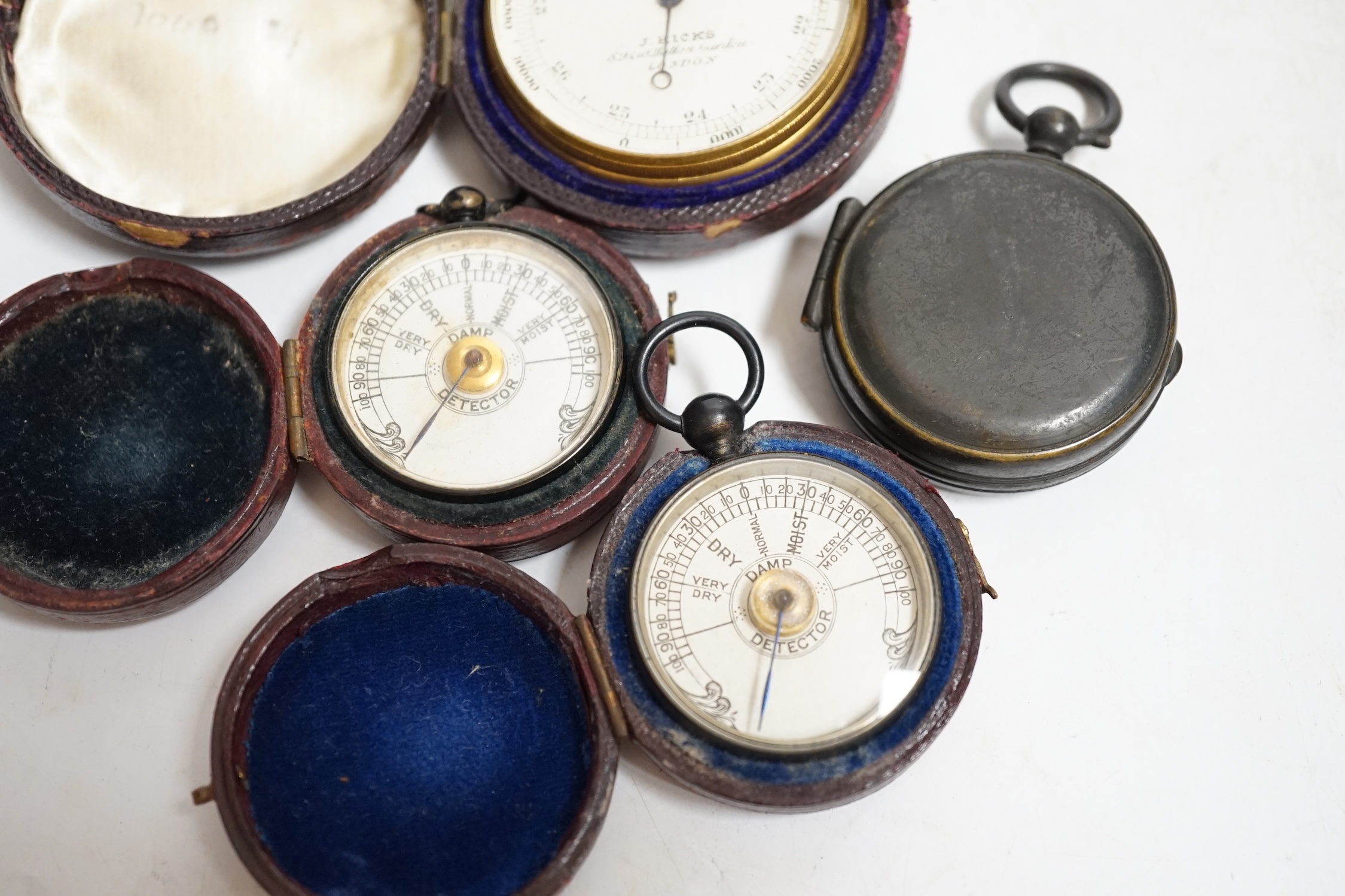 Two pocket damp detectors, a pocket barometer, and a compass, three with original leather cases. Condition - fair